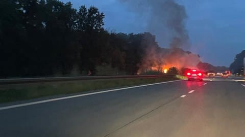 Rauch und Flammen sind nach einem Unfall auf der A5 bei Bruchsal zu sehen.