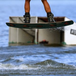 Symbolbild: Ein Mensch steht auf einem Wakeboard. In Rheinmünster im Kreis Rastatt ist eine Wakeboarding verletzt worden.