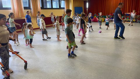 Kinder mit und ohne Behinderung tanzen bei der inklusiven Ferienfreizeit in Rastatt. Die findet immer in den Sommerferien in den Räumen des Kindergartens "Zwölf Apostel" statt.