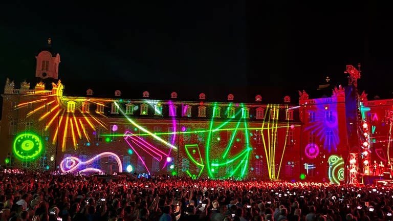 Bunte Lichtzeichnungen auf der Fassade des Karlsruher Schlosses zum Herbert-Groenemeyer-Konzert.