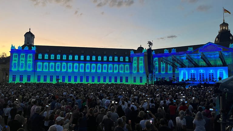 Über dem Karlsruher Schloss geht die Sonne unter und macht die Bühne frei für die Lichtershow zum Herbert-Grönemeyer-Konzert.