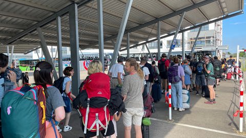 Reisende stehen am Bahnhof in Baden-Baden Schlange