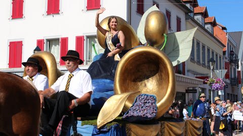 Umzug beim Zwetschgenfest 2023 in Bühl: Zwetschgenkönigin Alexandra winkt von ihrem Wagen.