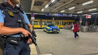 Polizeieinsatz am Abend nach einem Messerangriff am Karlsruher Hauptbahnhof. Ein bewaffneter Polizist steht vor dem Haupteingang.