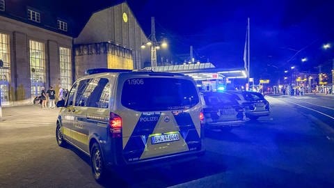 Polizeifahrzeuge stehen vor dem Haupteingang des Bahnhofs - Polizeieinsatz am Abend nach einem Messerangriff am Karlsruher Hauptbahnhof 