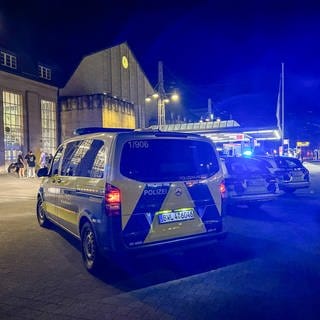 Polizeifahrzeuge stehen vor dem Haupteingang des Bahnhofs - Polizeieinsatz am Abend nach einem Messerangriff am Karlsruher Hauptbahnhof 