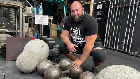 Dennis Kohlruss in Rastatt vor dem Nachbau der 124 Kilogramm schweren Louis Cyr-Hantel