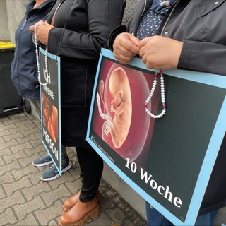 Schilder, mit denen Abtreibungsgegner vor Pro Familia in Pforzheim gegen Abtreibungen protestieren.