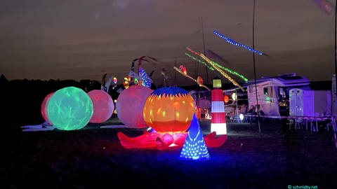 Viele bunte Drachen leuchten in der Nacht auf dem Drachenfest an der Schwanner Warte.