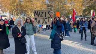 Demonstranten halten ein Plakat hoch. 