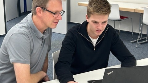 Sebastian Steppuhn und sein Vater sitzen am Computer.