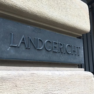 Das Schild des Landgerichtes in Karlsruhe. Hier wird ein Urteil erwartet. Zwei Brüder aus Pforzheim sollen den Tod ihrer 17-jährigen Nichte gefordert haben.