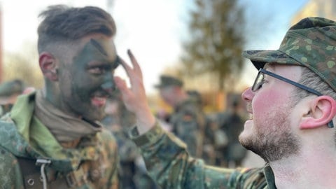 Ein Rekrut im Freiwilligen Wehrdienst im Heimatschutz in Bruchsal wird zur Tarnung im Gesicht geschminkt, bevor es in den Wald ins Biwak geht.