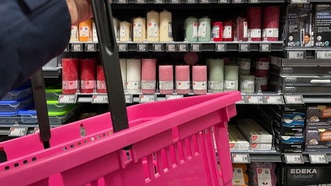 Pinker Einkaufskorb in Waldrbonner Supermarkt vor dem Kerzenregal