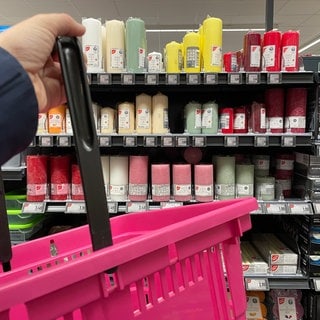 Pinker Einkaufskorb in Waldrbonner Supermarkt vor dem Kerzenregal