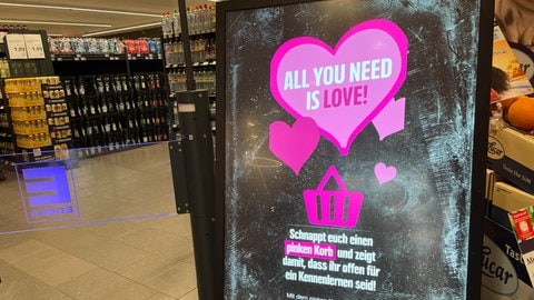 Am Eingang im waldbronner Supermarkt erklärt ein Schild, wie die pinken Körbe funktionieren