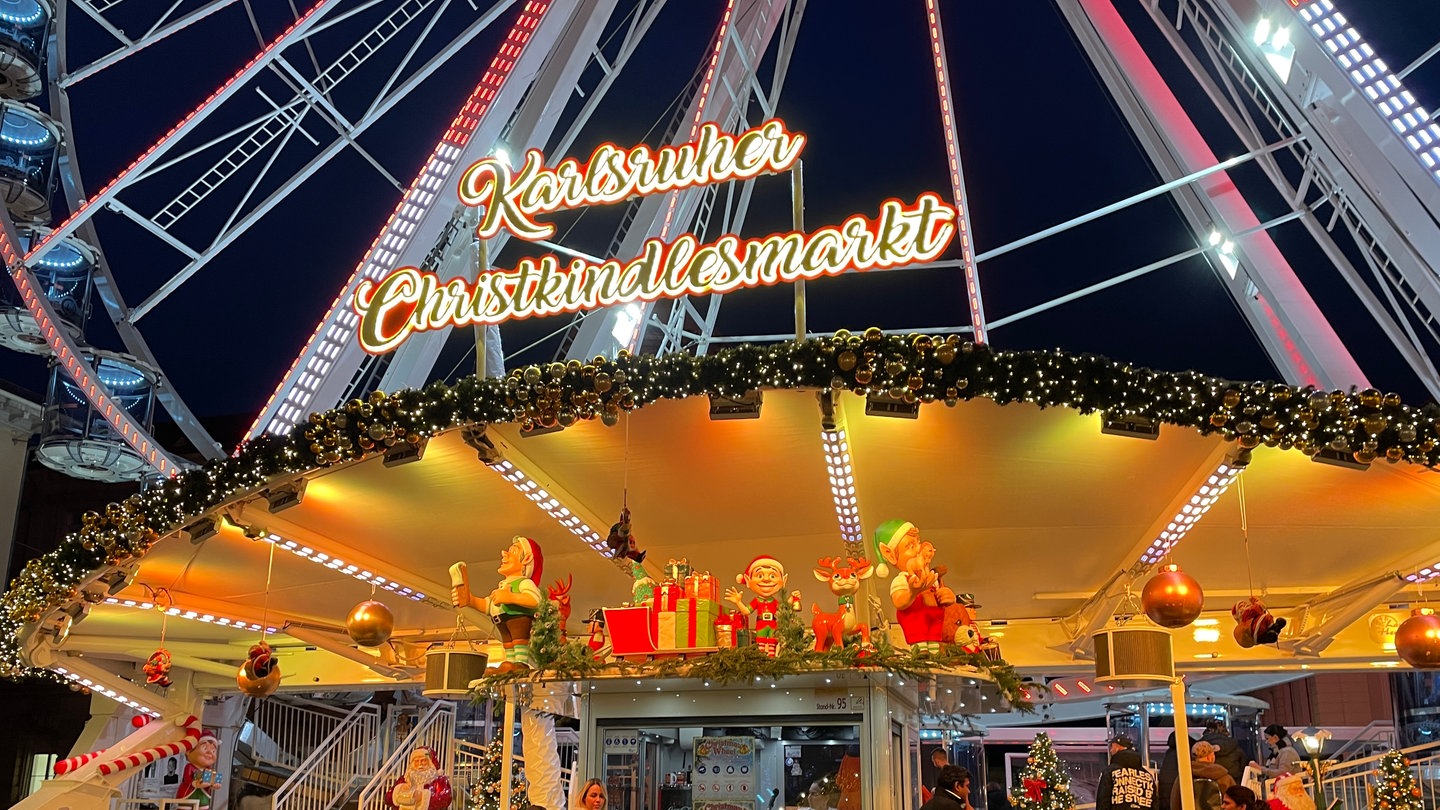 Weihnachtsmarkt Karlsruhe 2024: Das Riesenrad auf dem Marktplatz mit dem Schriftzug 