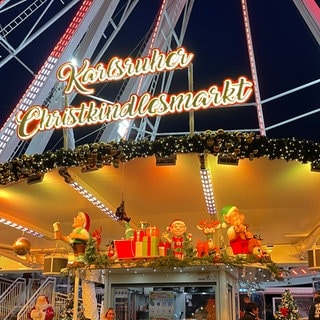 Weihnachtsmarkt Karlsruhe 2024: Das Riesenrad auf dem Marktplatz mit dem Schriftzug "Karlsruher Weihnachtsmarkt".