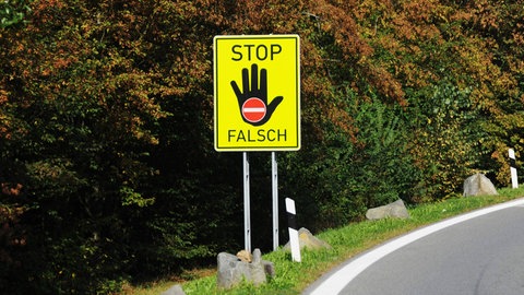 Ein Hinweisschild auf dem "Stop" steht und Falschfahrer davon abhalten soll, in die verkehrte Richtung zu fahren.