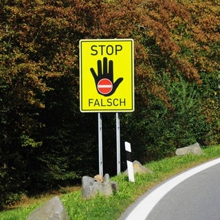 Ein Hinweisschild auf dem "Stop" steht und Falschfahrer davon abhalten soll, in die verkehrte Richtung zu fahren.