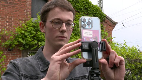 Potraitfoto von Benedikt Döllmann, der eine Videoaufnahme mit seinem Smartphone macht. Er kandidert für die Grünen in Tübingen.