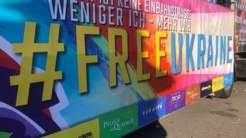 Bunter Mottowagen beim CSD in Mannheim zeigt den Leitspruch "Free Ukraine"