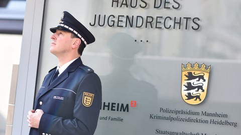 Ein Polizist am Hauseingang des "Haus des Jugendrechts" in Mannheim
