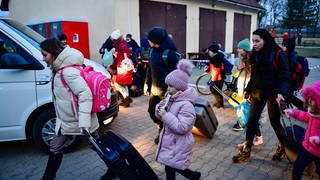 Flüchtlinge aus der Ukraine gehen über den Hof einer Flüchtlingsunterkunft