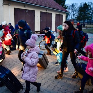Flüchtlinge aus der Ukraine gehen über den Hof einer Flüchtlingsunterkunft