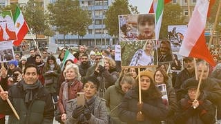 Viele Menschen protestieren in Mannheim mit Transparenten gegen das Iran-Regime