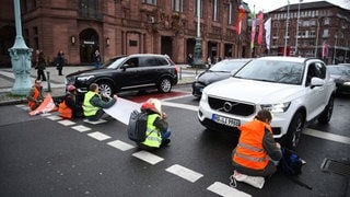 Klimaaktivisten sitzen auf Straße und blockieren den Verkehr