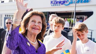 Königin Silvia von Schweden winkt vor dem Schiff der Weißen Flotte bei einer Benefizveranstaltung zugunsten der World Childhood Foundation