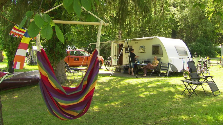 Camper mit Hängematte im Vordergrund