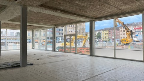 Das ehemalige Theatercafé des Mannheimer Nationaltheaters ist komplett entkernt und leer. Durch die Glasscheibe kann man auf die Baustelle am Goetheplatz schauen.