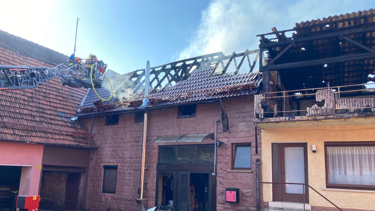 Die Feuerwehr löscht auf einem Leiterwagen den Dachstuhl des Hauses in Elztal-Dallau.