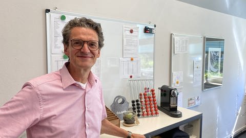Jörg Schuchardt, Rektor der Waldschule in Büro vor Zettelwand und Kaffeemaschine