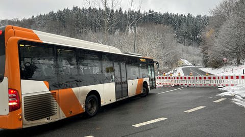 Ein Bus steht vor einer Straßenabsperrung.