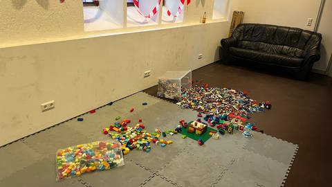 Ein Baustellenschild wurde aufgestellt und Flatterband aufgehängt. Auf dem Boden liegen LEGO-Steine