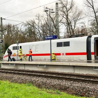 Ein ICE steht am Bahnhof Malsch-Rot (Rhein-Neckar-Kreis), Feuerwehrleute stehen auf dem Bahnsteig und befinden sich im Zug.