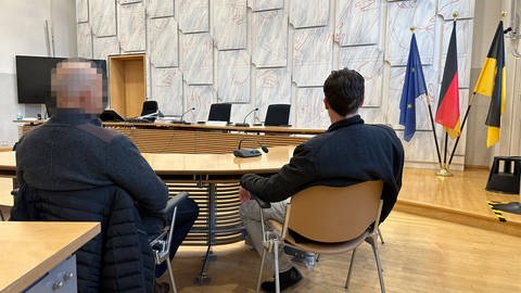 Zwei Polizisten sitzen im Mannheimer Amtsgericht. 