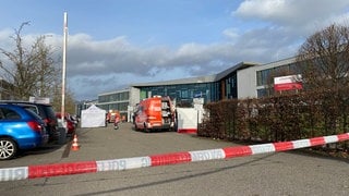 Einsatzkräfte vor einem Gymnasium nach Gewalttat an Schülerin