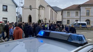 Menschen in einem Trauerzug in St. Leon-Rot