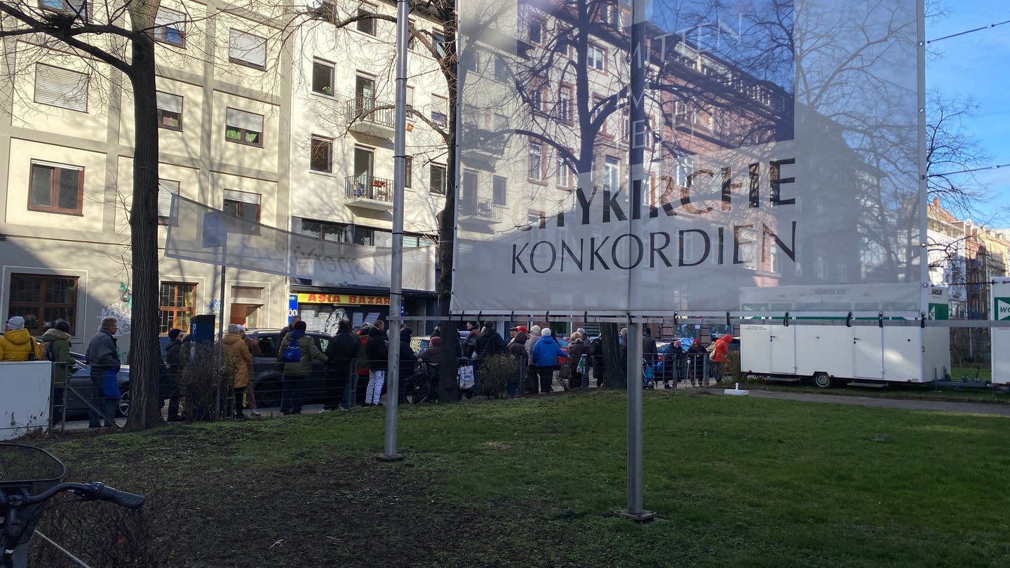 Menschen warten vor der Vesperkirche Mannheim auf Essen