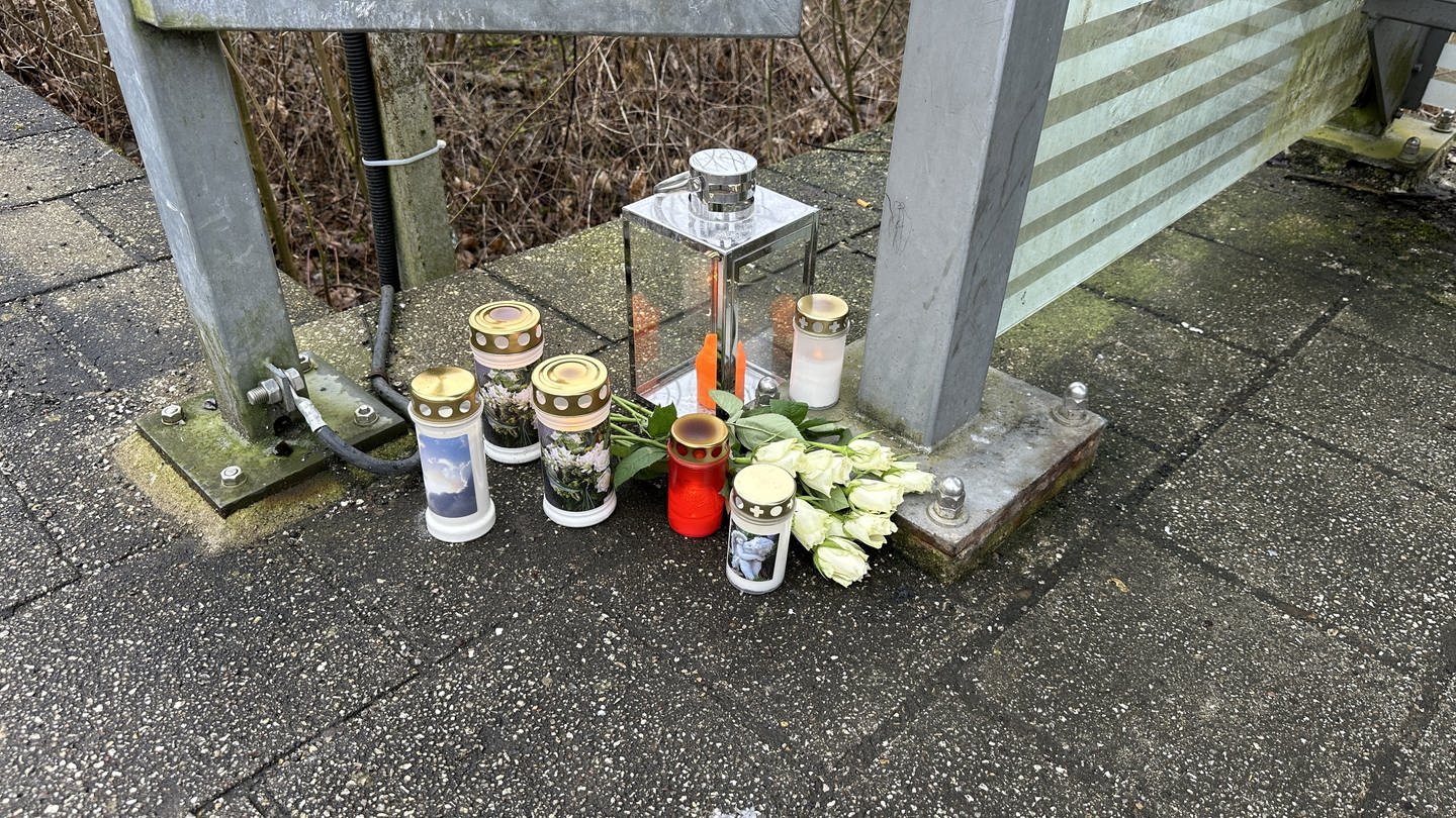 Kerzen und Blumen auf dem Boden am Bahnübergang Adelsheim-Nord