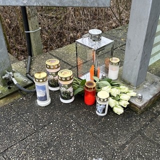 Kerzen und Blumen auf dem Boden am Bahnübergang Adelsheim-Nord