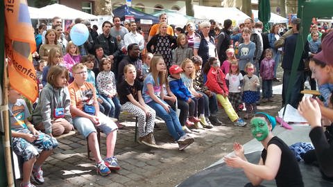 Kinder bei Straßenfest in Mannheim schauen sich Theaterstück an