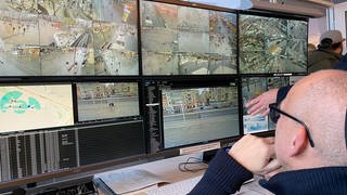 Videoüberwachung mit KI in Mannheim, Polizeibeamter vor Bildschirm