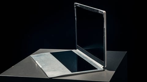 Laptop vor schwarzem Hintergrund ohne Tastatur und Maus