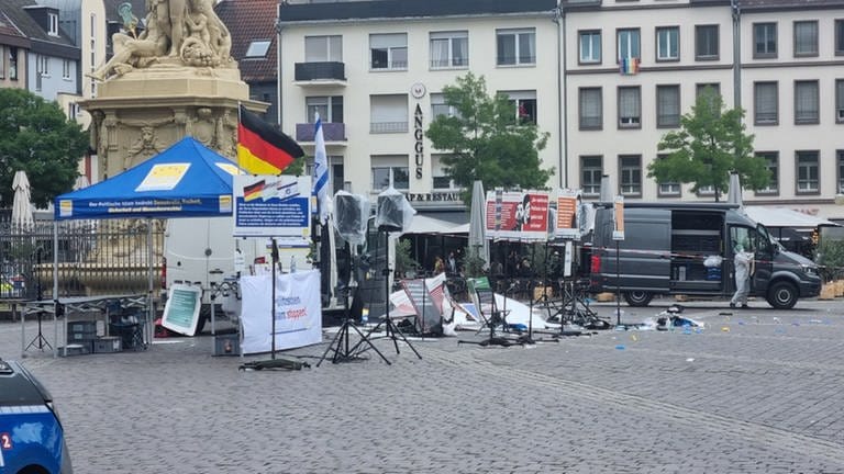 Mitarbeiter der Spurensicherung nach einer Messerattacke auf dem Mannheimer Marktplatz: Teile eines Standes sind zerstört und liegen am Boden