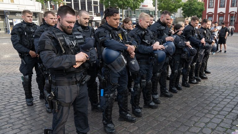 Polizisten in Uniform stehen auf dem Mannheimer Marktplatz, um zu trauern